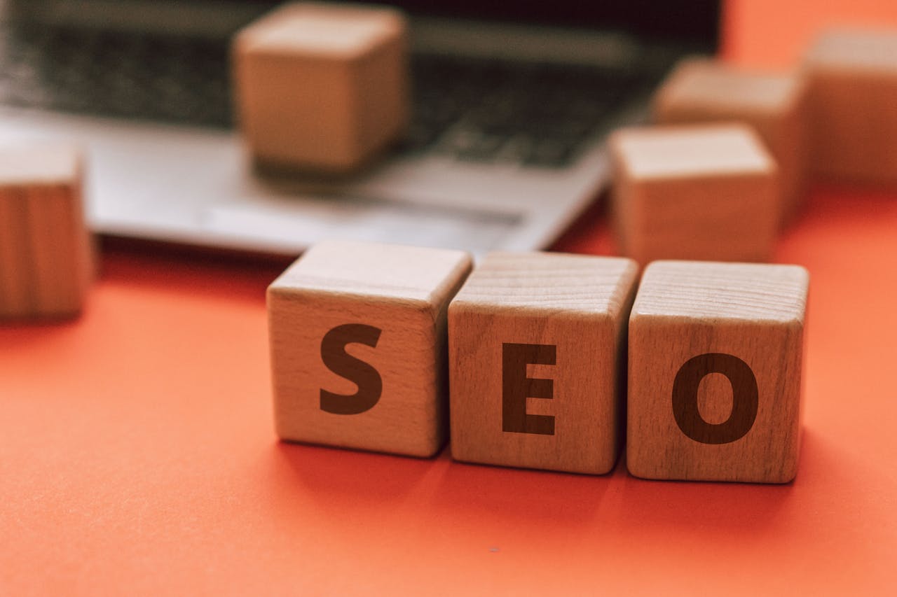 services-04 Wooden blocks spelling SEO on a laptop keyboard convey digital marketing concepts.